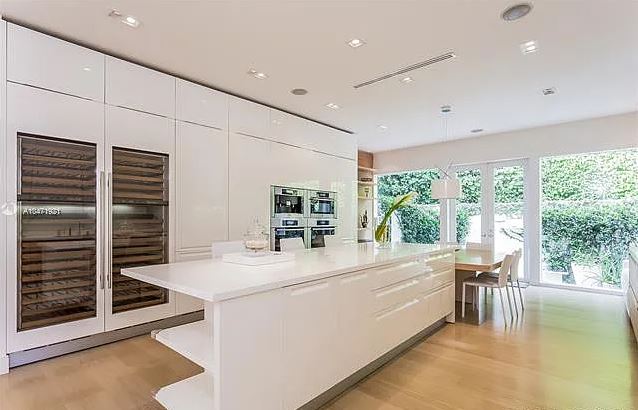 The white kitchen provides a functional space to cook and entertain with views of the garden