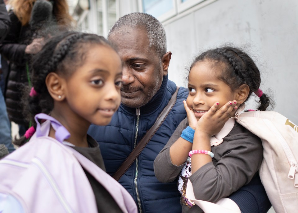 Lamar, 4, (R) looks at her father Mohamed Elamin and her sister Lujain, 6