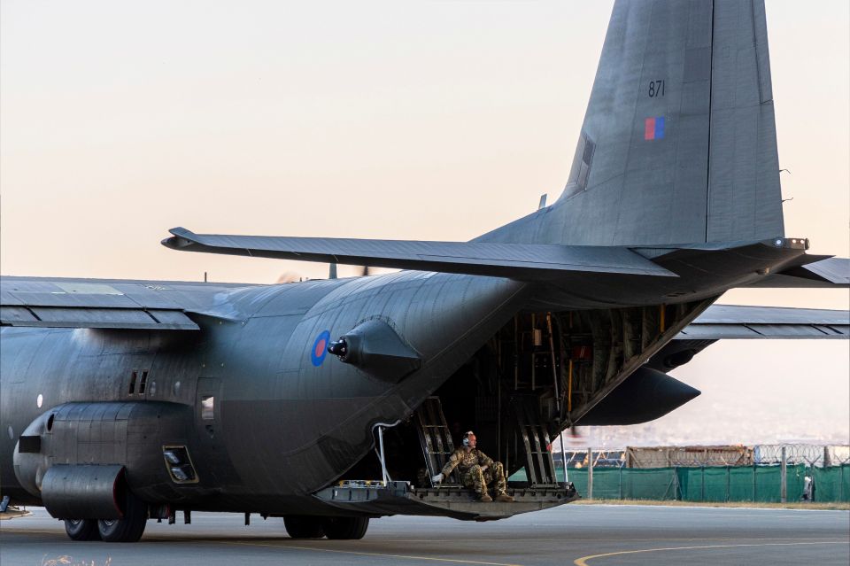 An airman sits on the tailgate of the C-130 bound for Sudan