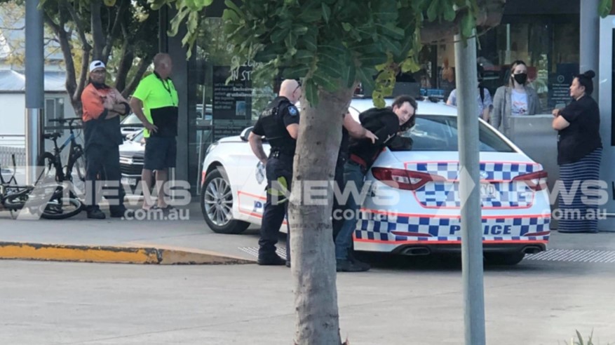 Black-clad Bourke is arrested by police outside the Aldi near Brisbane