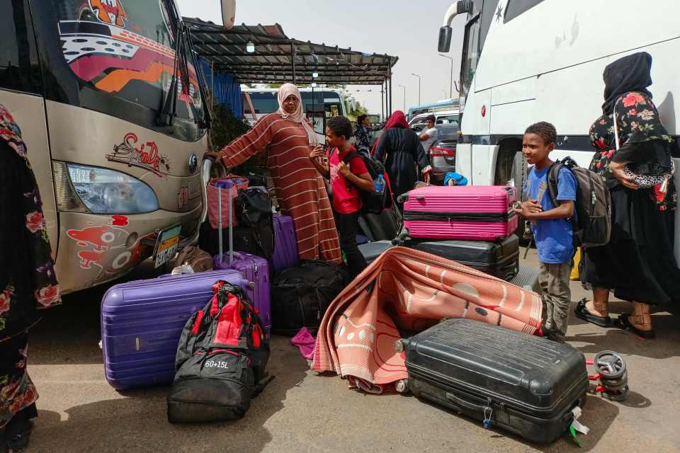 Passengers fleeing war-torn Sudan disembark at the Wadi Karkar bus station