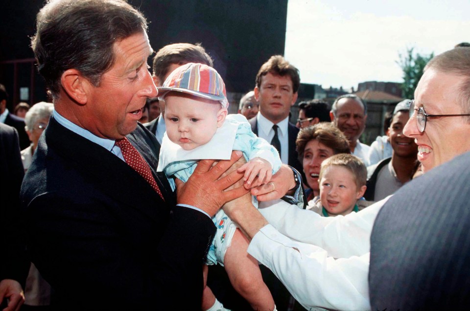 Prince Charles with a baby in Birmingham in 1995