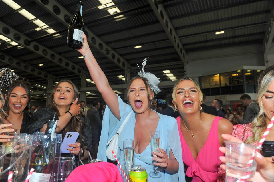 Drinks appear to be flowing as guests shelter from the rain at Aintree