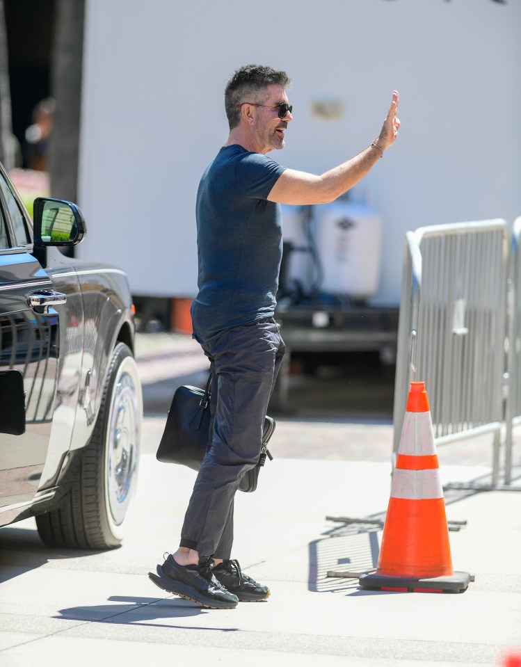 Simon gave a quick wave to the cameras and fans around him as he cut a casual figure