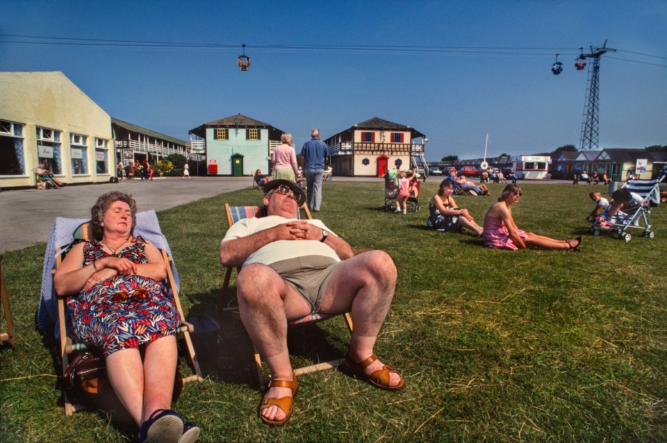 Holidaymakers nap in the sports field of Butlins Holiday Camp