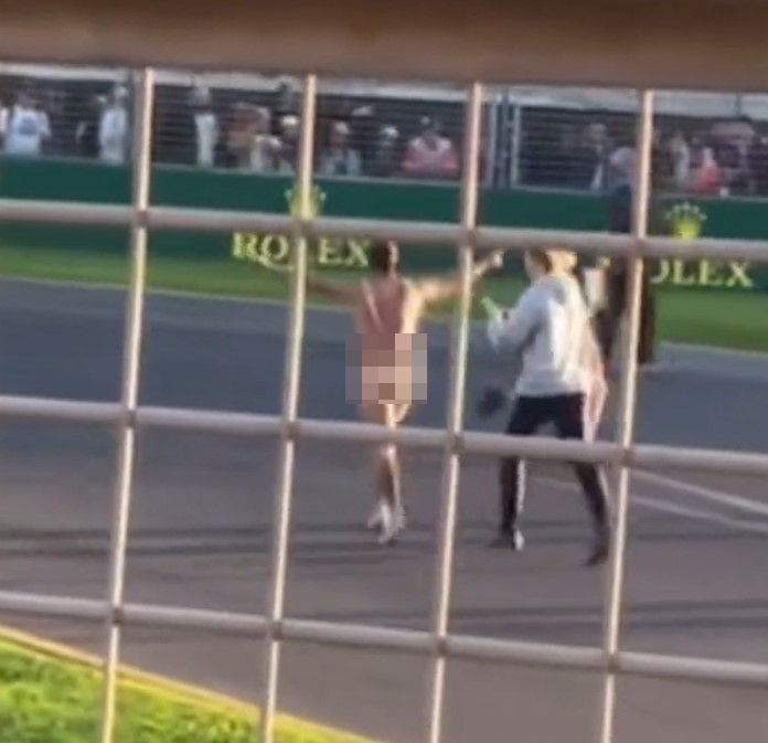 A streaker runs naked along Australian GP track before he is tackled by security