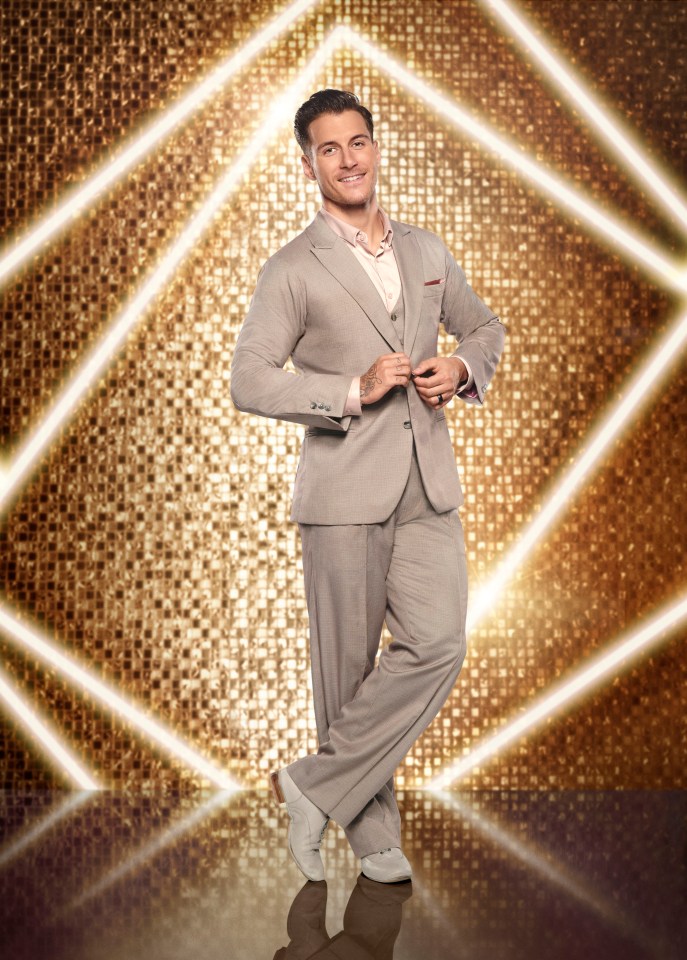 a man in a suit is standing in front of a gold background