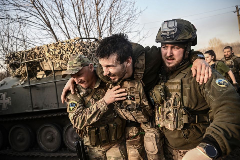 A wounded Ukrainian serviceman is being carried away from the frontline