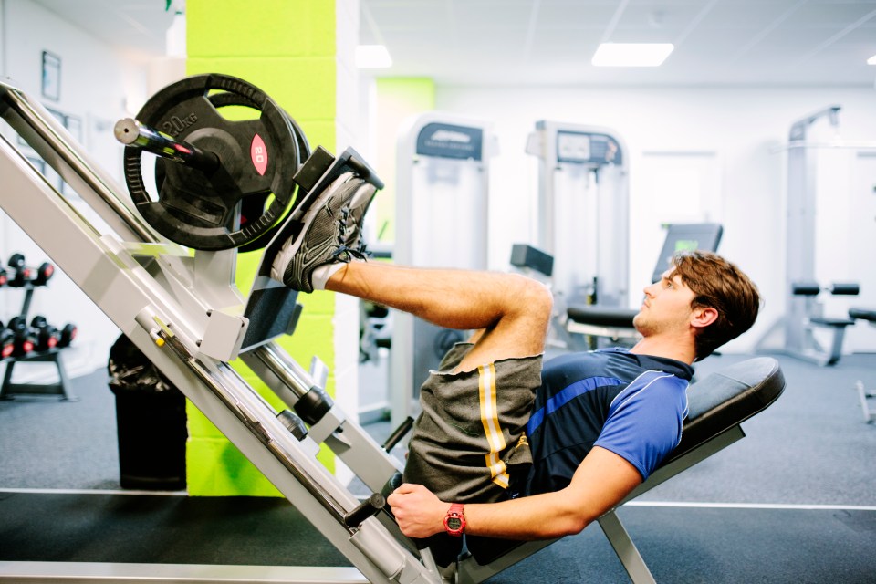 A man using a leg press in a gym