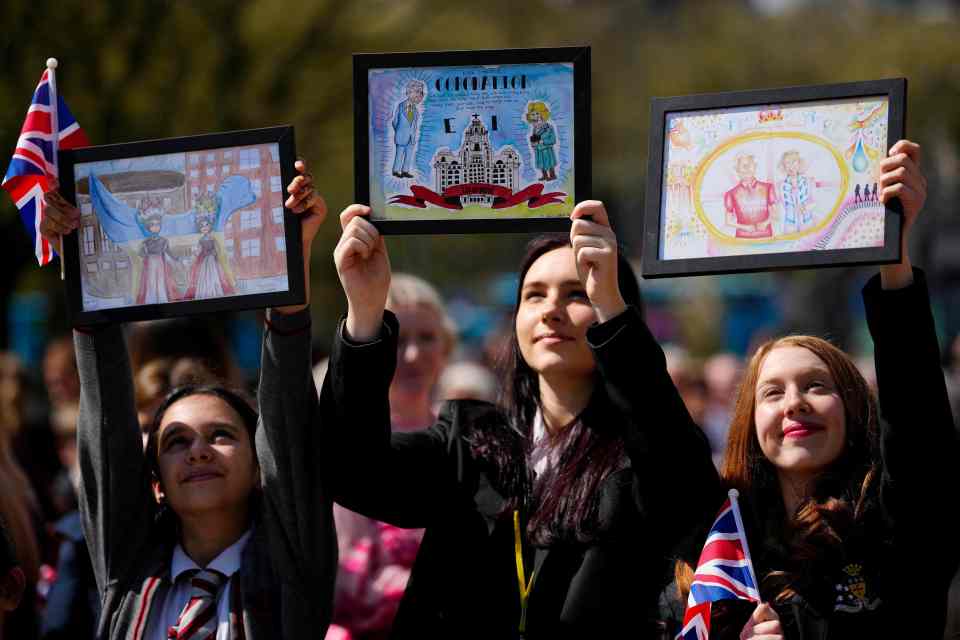 Youths held framed drawings before the monarch arrived