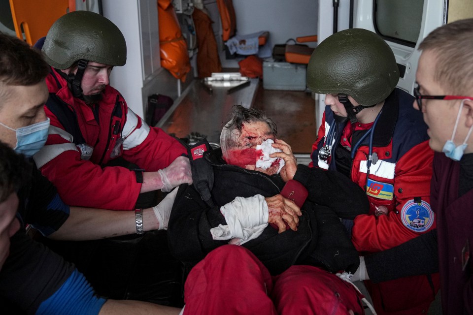 Paramedics move a wounded in shelling civilian onto a stretcher into a hospital in Mariupol