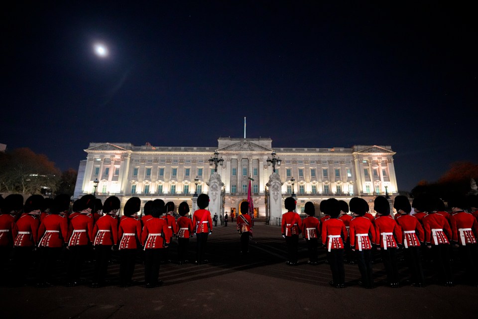 Members of the elite military guard stand in front of Buckingham Palace in Central London