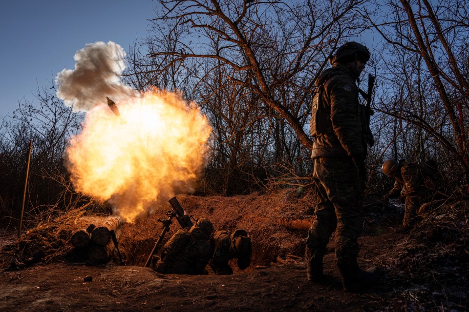 FUkrainian servicemen fire a 120mm mortar towards Russian positions