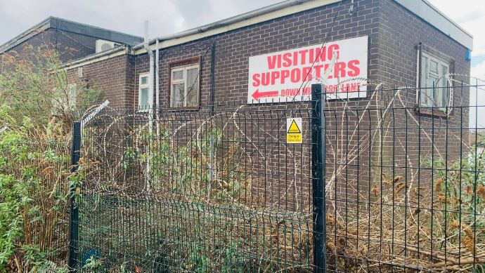 Signs for visiting supporters are now surrounded by overgrown weeds and plants