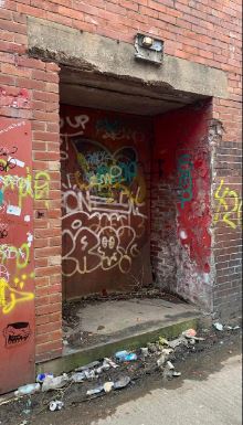 Graffiti covers the external walls of the neglected stadium