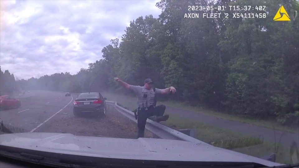 Amazingly the officer escaped serious injury and is seen jumping over the barrier to call for help