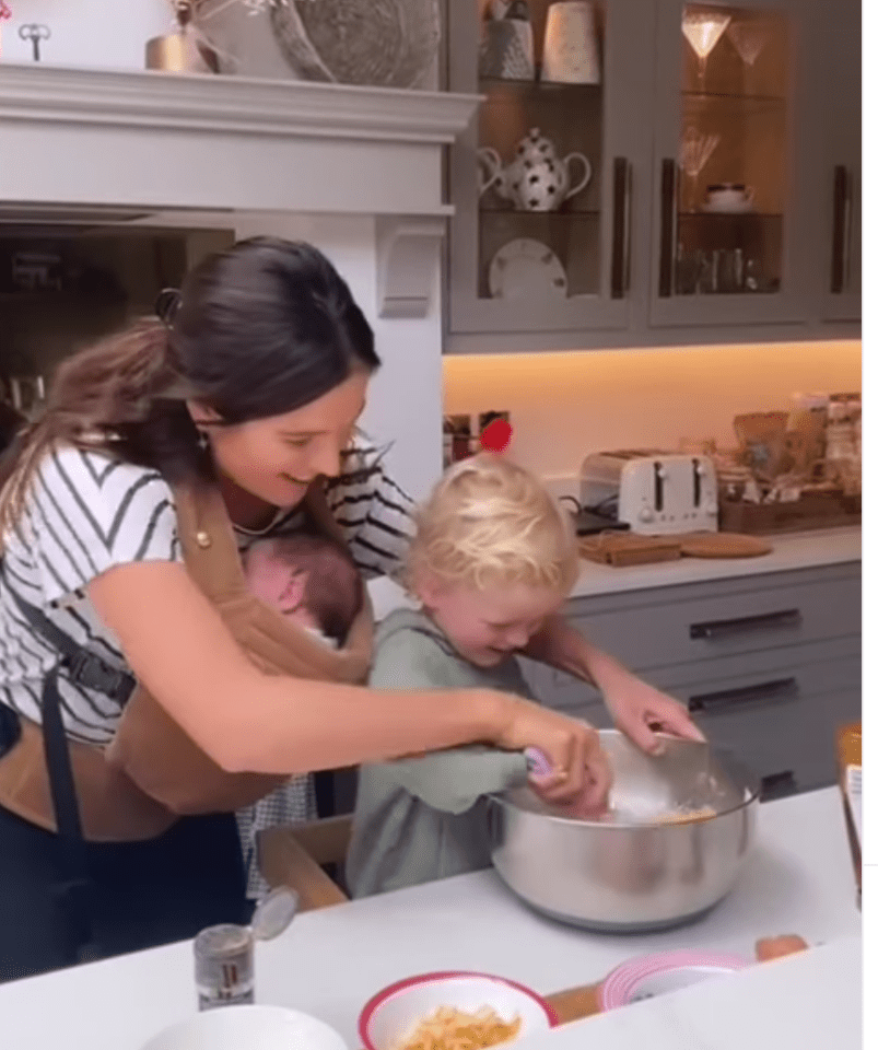 Binky was baking with her two year old Wolfie while holding newborn Wilder in a baby carrier