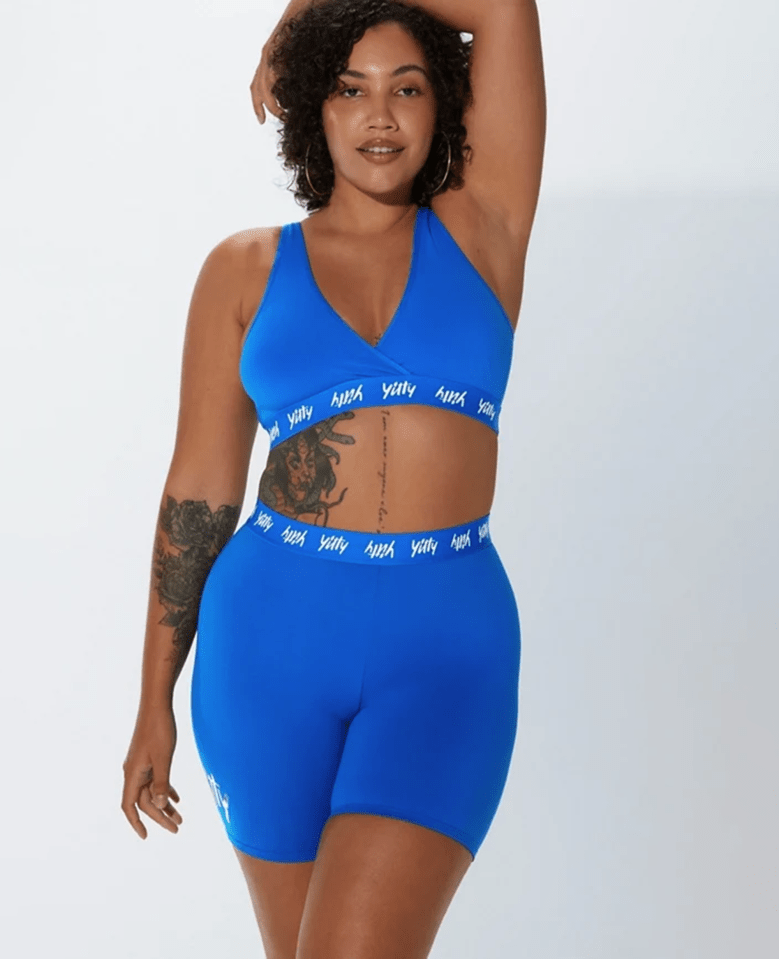 Woman in blue Yitty high-waist logo sports bra and shorts.