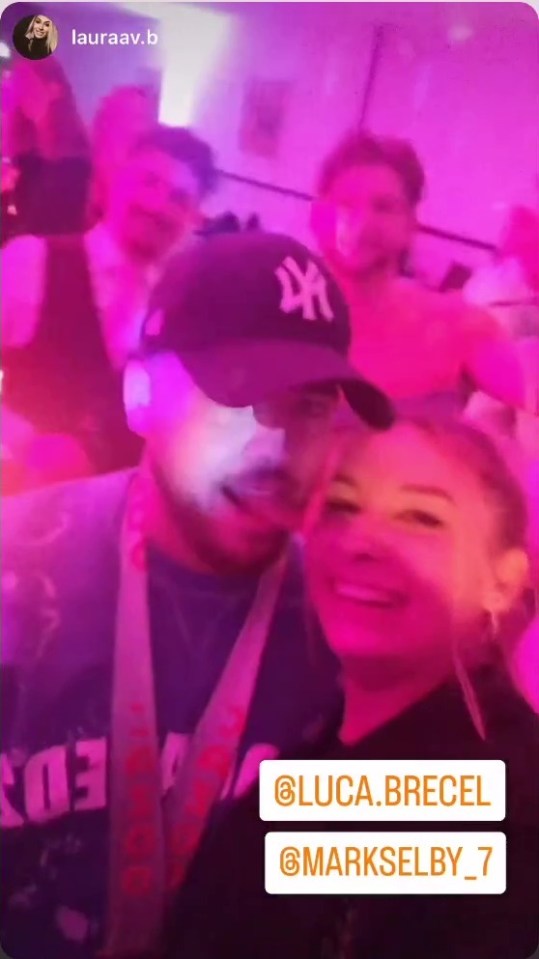 The Belgian Bullet playfully sticks his tongue towards his girlfriend’s cheek as they party to Queen’s ‘We Are the Champion’