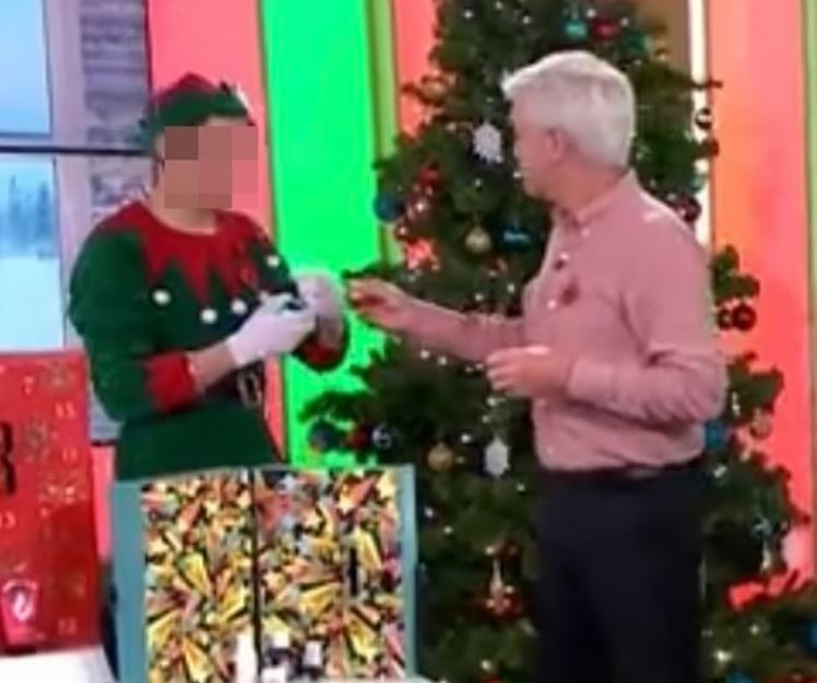 Phillip Schofield hands his younger lover a drink in a Christmas segment on This Morning