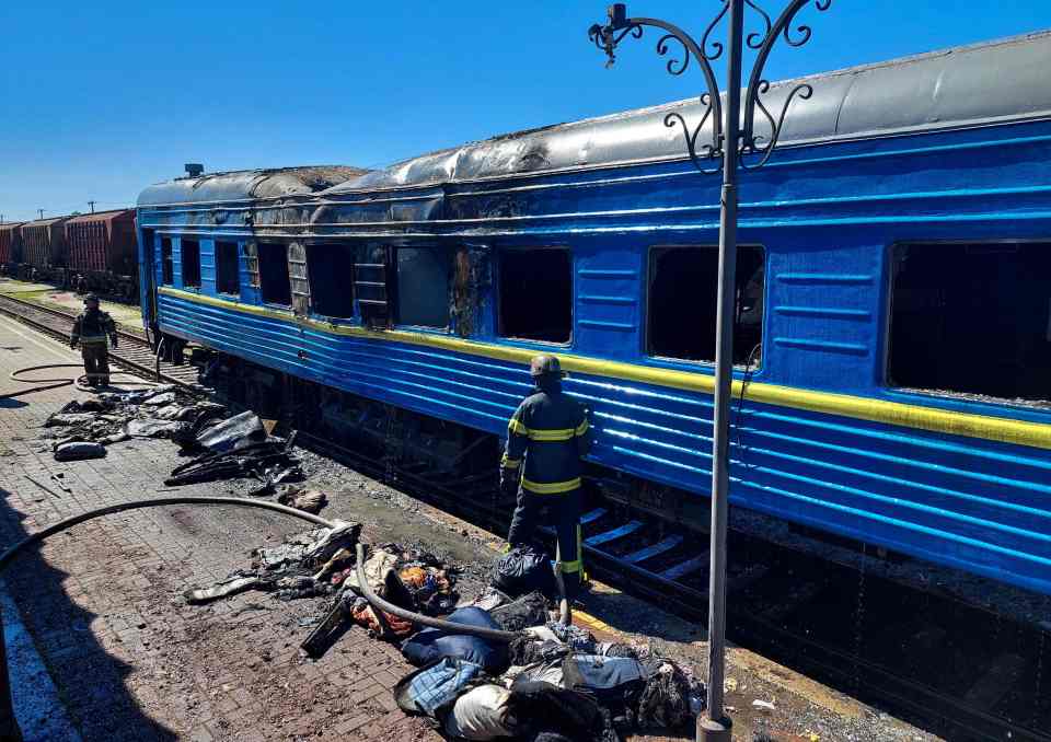 A burned train carried and belongings on the platform at the station