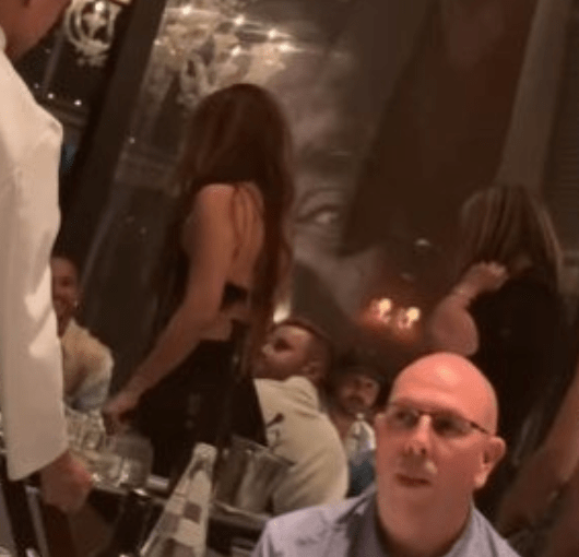 Lewis appears to smile as Shakira approaches his table over the weekend