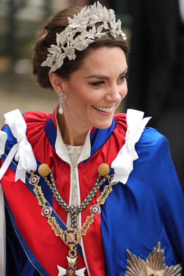 Kate is wearing a formal robe alongside an Alexander McQueen dress in ivory silk crepe with silver bullion and thread work embroidery