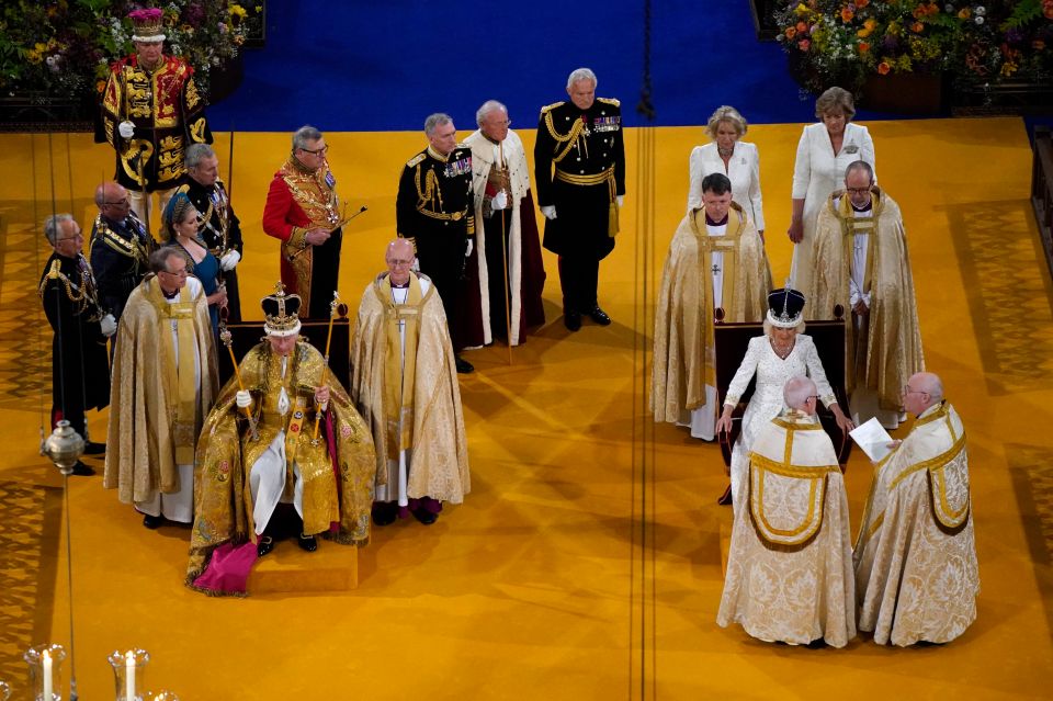 King Charles and Queen Camilla sit side by side on their thrones after being crowned