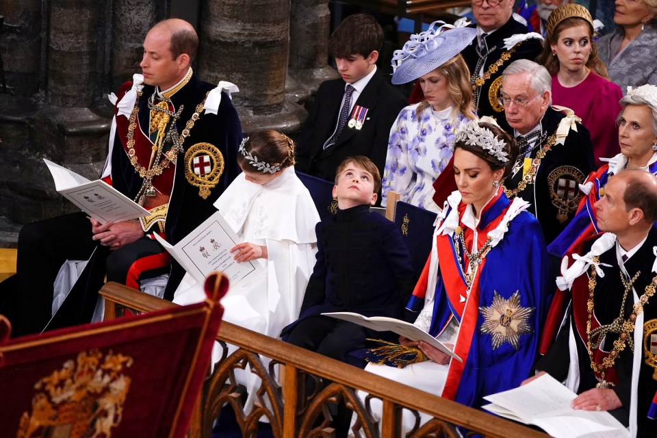 Prince Louis looks up as Kate follows the order of service