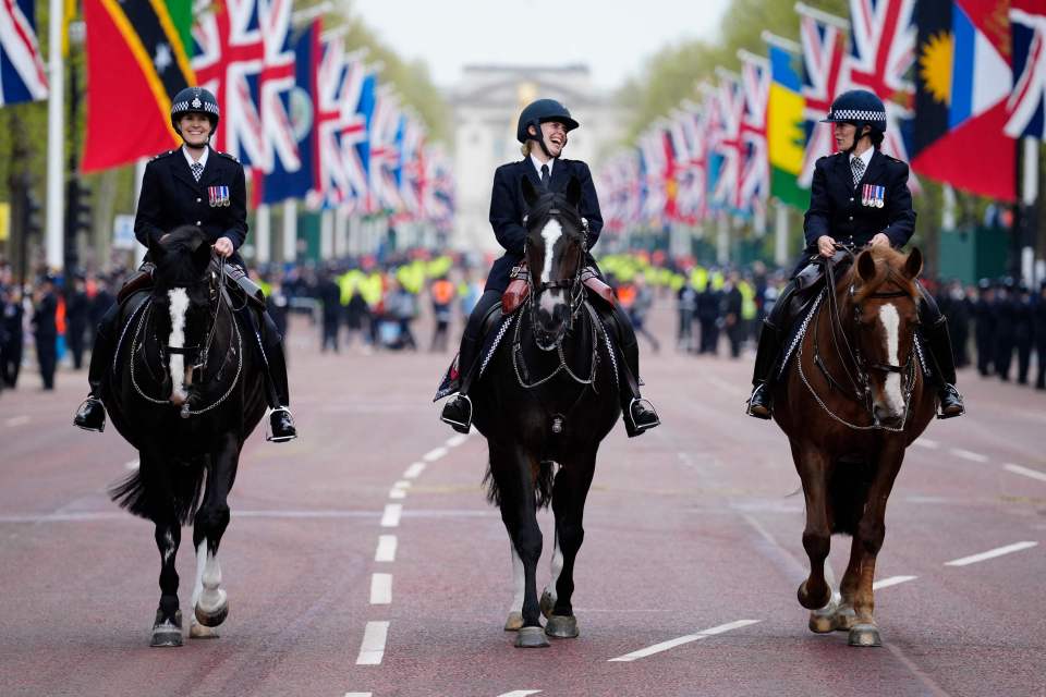 Mounted police officers ride their horses on the route of the King's coronation