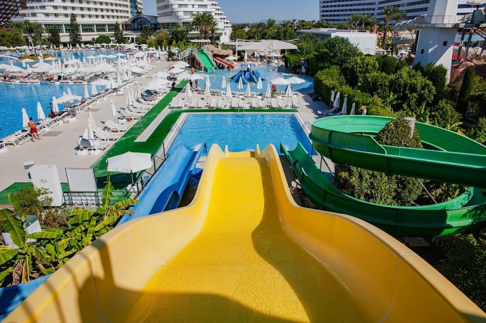 a water park with a yellow slide and a green slide