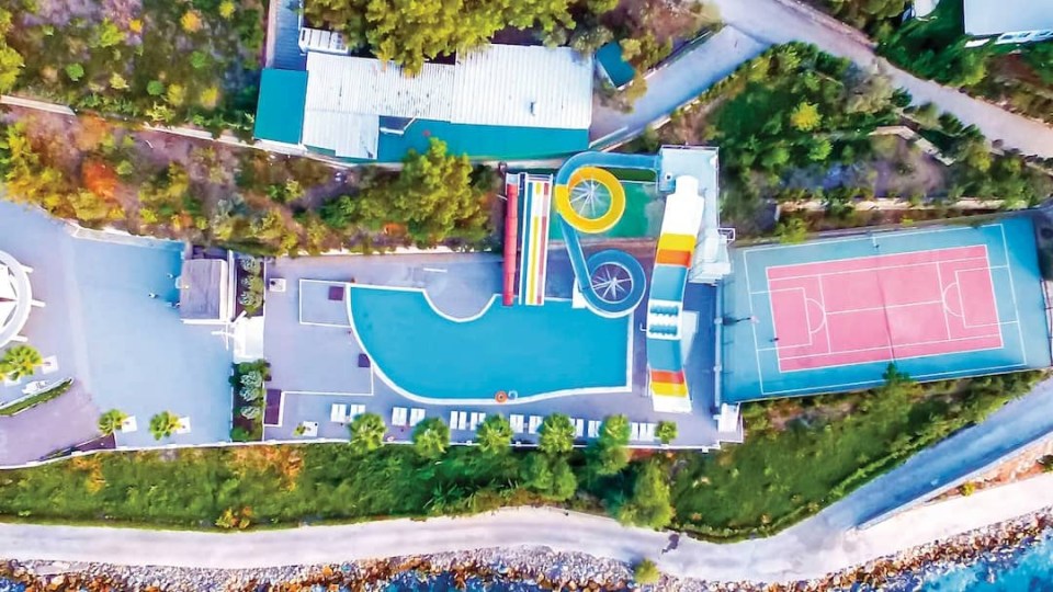 an aerial view of a water park with a tennis court