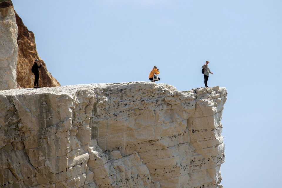 A pair of tourists were snapped taking photos dangerously close to the edge