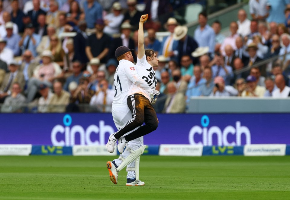 Bairstow carries the man off the pitch as he holds his fist aloft