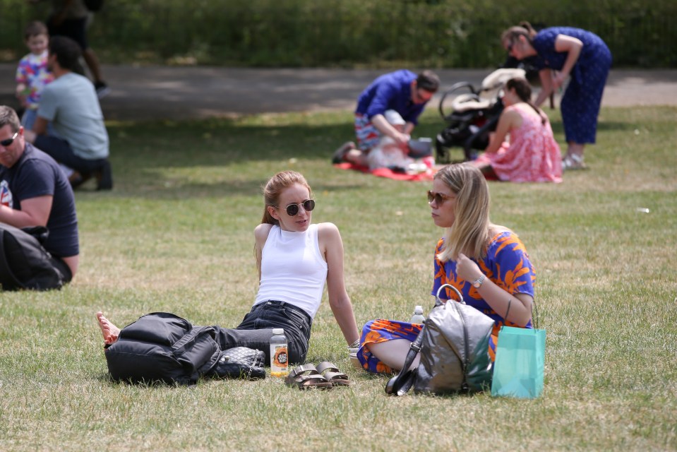 Pals relax in St James's Park, London, which could see temperatures hit 25C on Monday