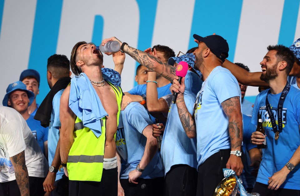 Some of the Man City players squirted a drink into Grealish's mouth on stage