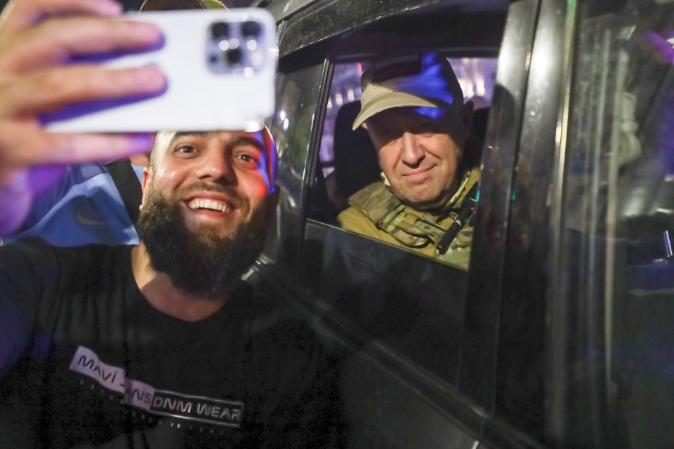 He smiles as a fan takes a snap with him