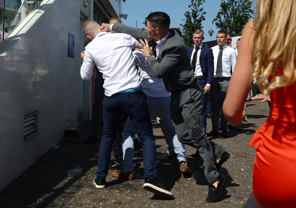 Lads in suits grappled on the side of the racecourse