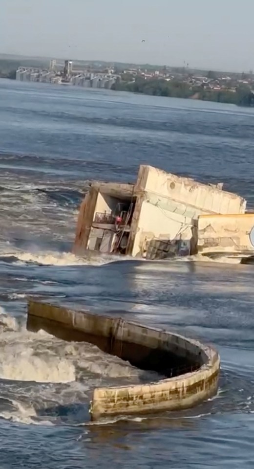 Water can be seen pouring through the remains of the damaged dam