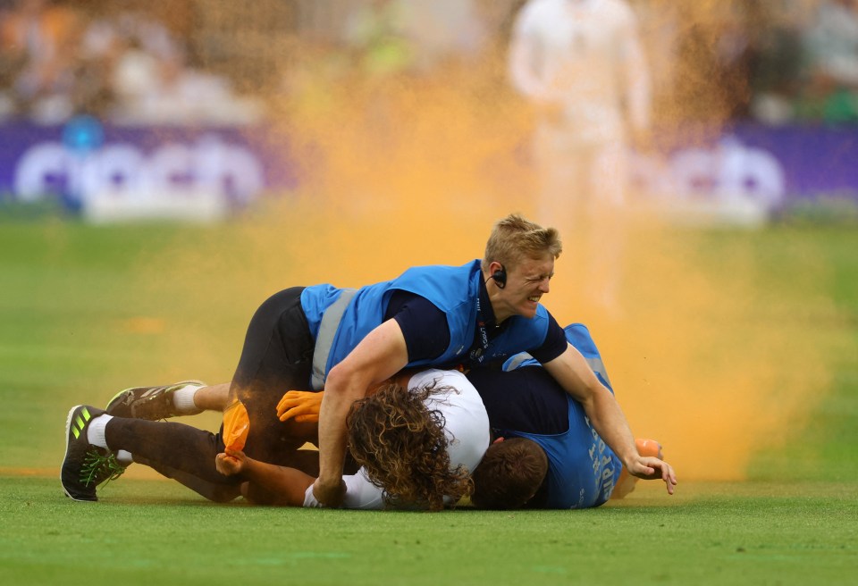 A protester is tackled to the floor by security staff