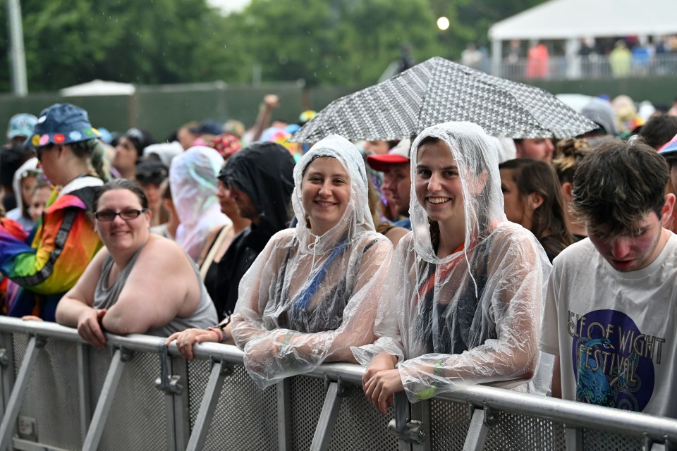 Isle of Wight Festival goers protect themselves from the rain earlier today