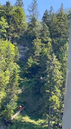 Rescue teams seen trying to reach the woman as they scaled the ravine