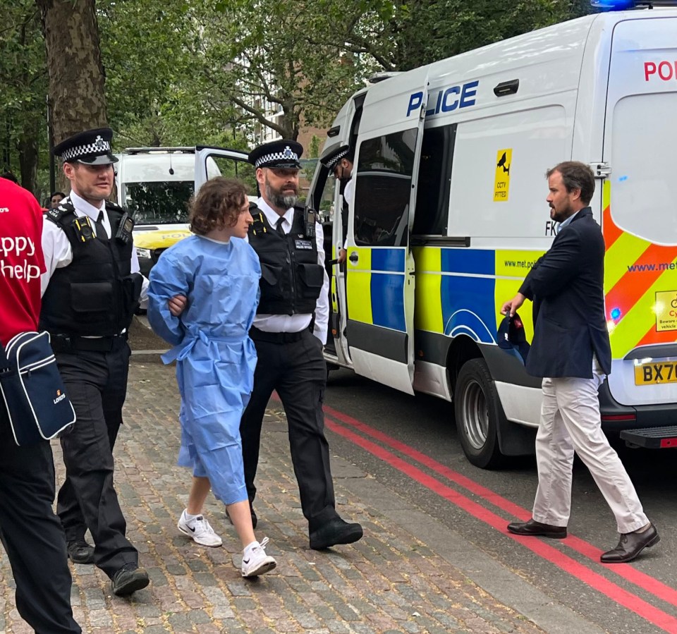 One of the protesters is taken away by police