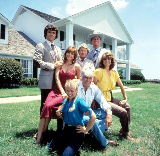 a group of people posing in front of a house