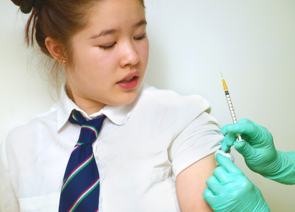 A schoolgirl receiving a vaccine