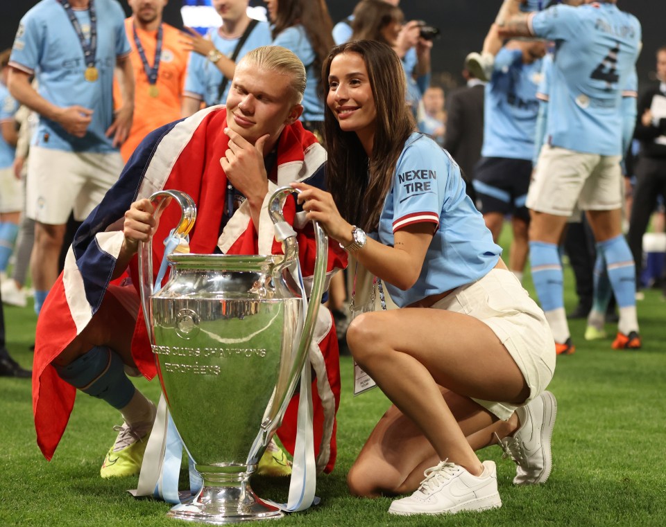 Man City goal machine Erling Haaland and girlfriend Isabel Haugseng Johansen pose with the Champions League trophy