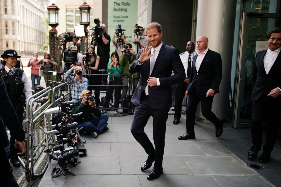 Prince Harry waves to cameras outside the High Court in London