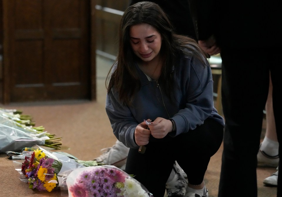 Distraught friends of the students laid flowers at a vigil tonight