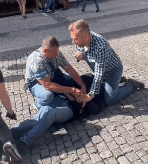 Plainclothes police detain another fan in the street after the brawl