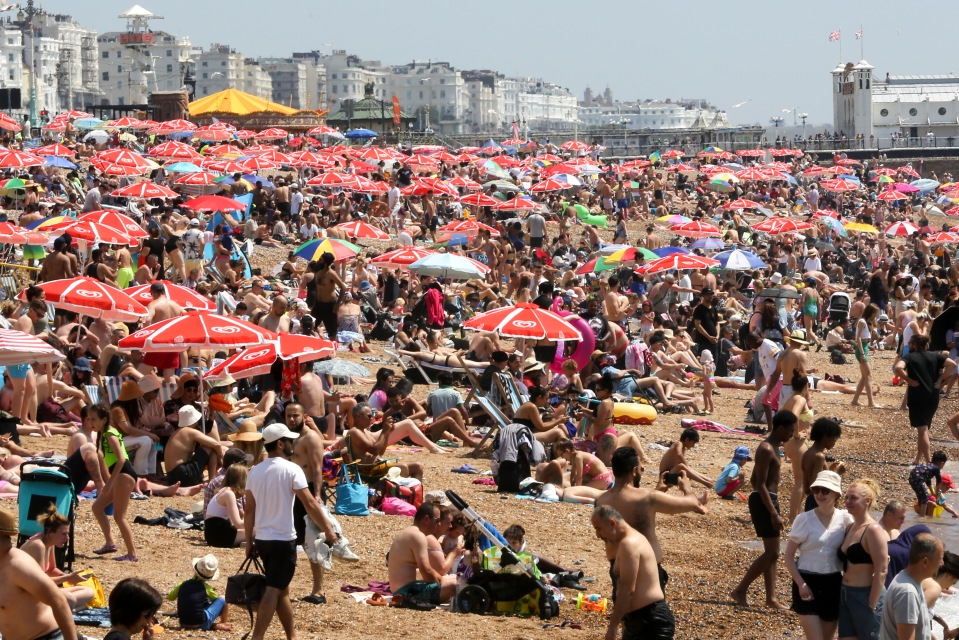 Sun-seekers enjoy the Brighton coast in East Sussex on a hot and sunny day yesterday